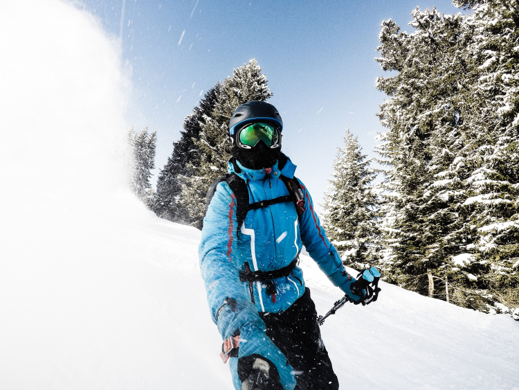 Sport d'hiver et vue : homme faisant du ski et portant un masque de ski au dessus de ses lunettes de vue, pour protéger ses yeux du soleil et de ses UV